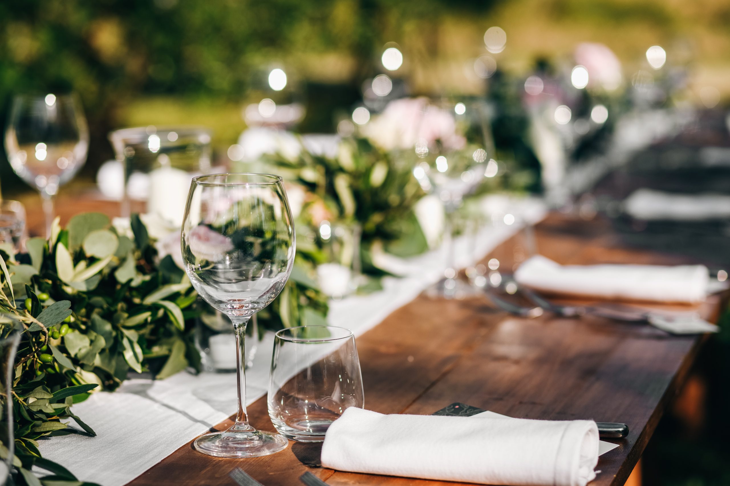 Floral garland of eucalyptus lies on the wedding dinner table